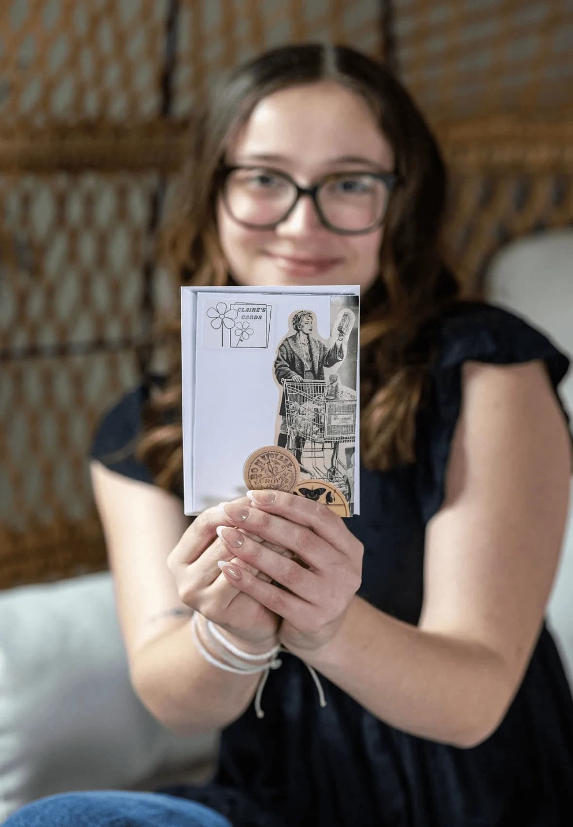 A close-up of Claire's handmade cards in her hands